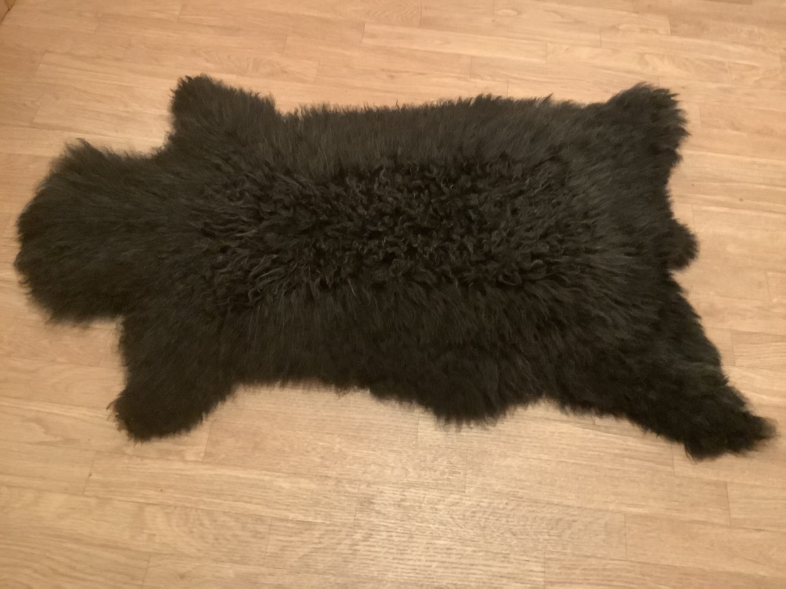 Black sheep skin rug